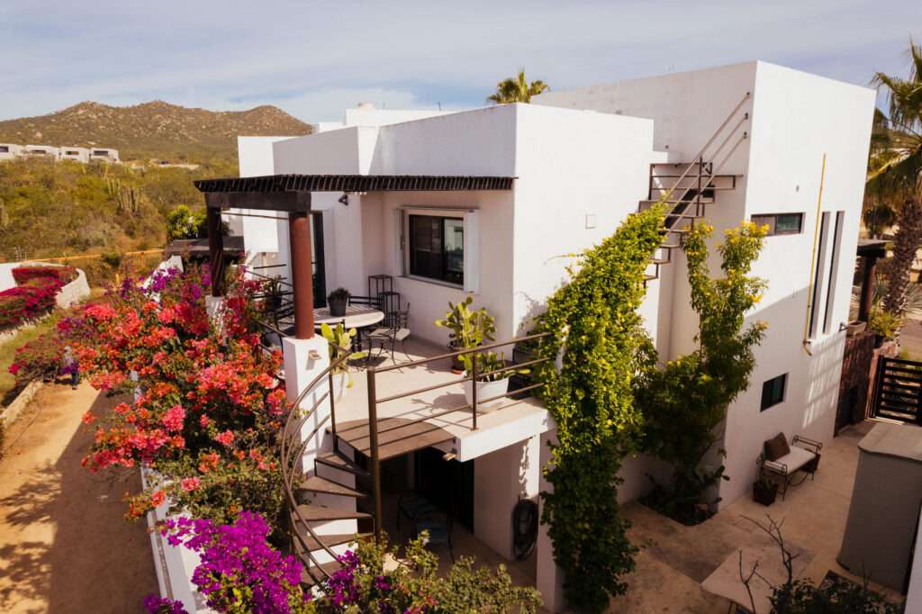 Los Cabos Casa Mex-Agaves Situated within the Casa Mexicana - Agaves community, this thoughtfully designed three-bedroom residence offers a functional and well-planned layout. The main level features a bedroom with an en-suite bathroom and walk-in closet, ideal for guests, multigenerational living, or those seeking stair-free access.A spacious outdoor terrace on the first floor, surrounded by tropical landscaping, provides a serene setting for both relaxation and entertaining. With multiple seating areas, it stands out as a unique feature within Casa Mexicana. The upper level includes two additional bedrooms, each with en-suite bathrooms and walk-in closets, along with the home's main living and kitchen areas. The indoor spaces are seamlessly connected to an additional terrace, enhancing the home's indoor-outdoor living appeal.Additional features include a dedicated laundry area, a two-car garage, and accordion-style hurricane shutters, combining comfort with practicality and peace of mind. – CTO ISLA SANTA MARGARITA, MZ 5, Cabo Corridor, BS